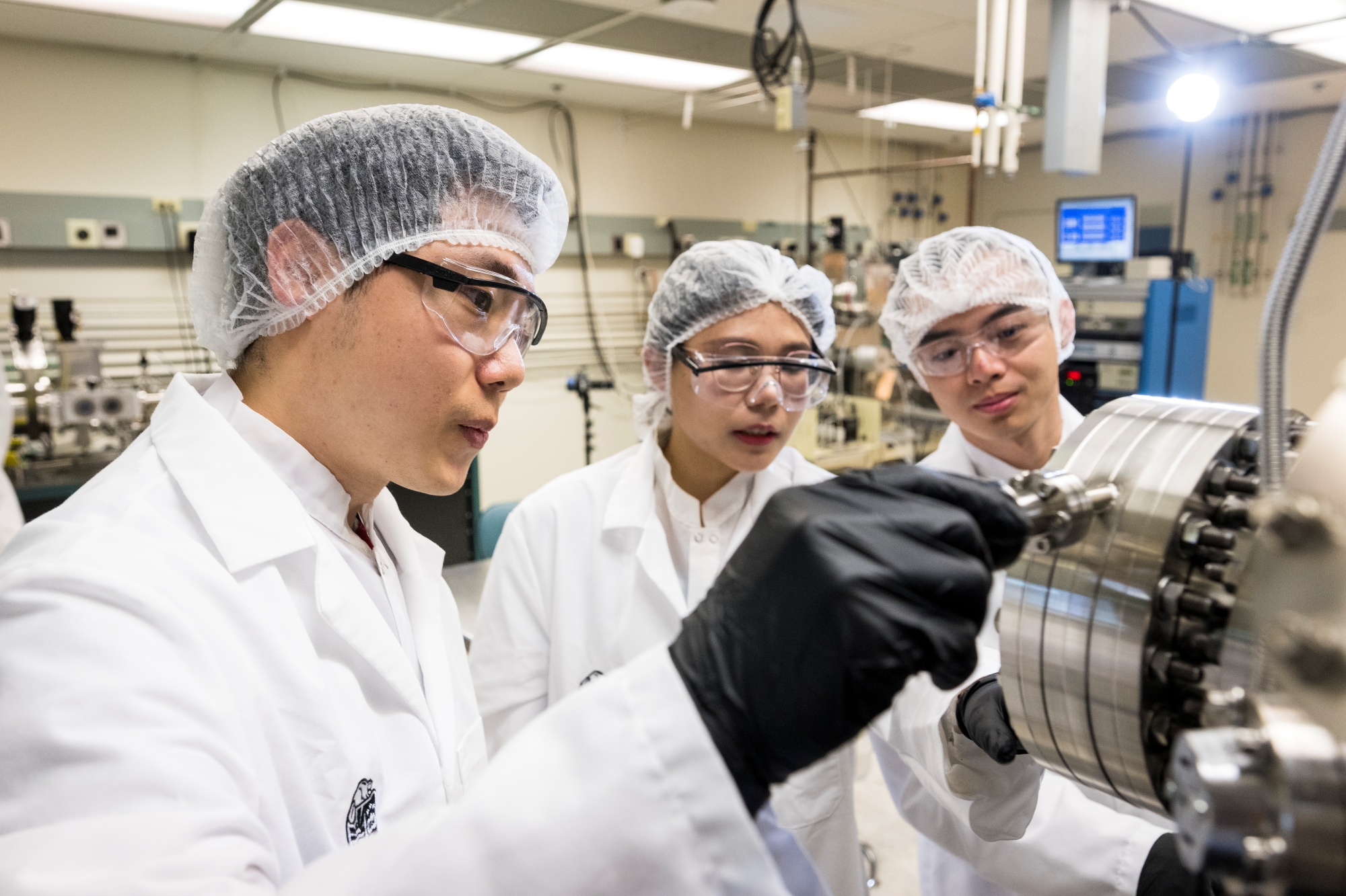 Three people looking at machine